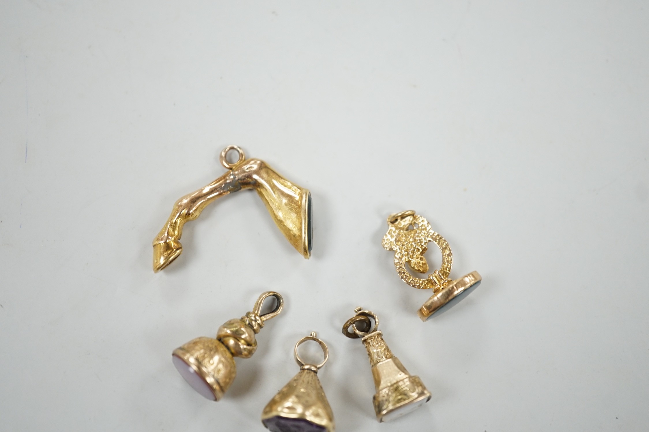 A Victorian yellow metal overlaid and bloodstone set fob seal, modelled as an entwined serpent, 22mm, two other similar fob seals set with chalcedony an a similar fob seal set with bloodstone and modelled as the leg of a